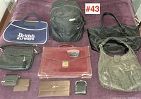 Various handbags and wallets laid out on purple fabric, showing all items together