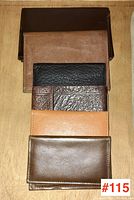 Six assorted leather wallets and card cases arranged in a stack showing different colors and textures