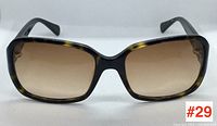 Front view of COACH tortoise shell sunglasses with brown gradient lenses