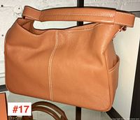 Front side view of tan Tod's handbag showing overall shape and strap