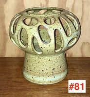 Front angled view of the vintage Canadian studio pottery vase showing organic cutouts and speckled glaze.