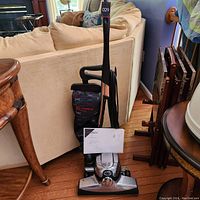 Full view of Kirby upright vacuum cleaner showing handle, vacuum bag, and metal base.
