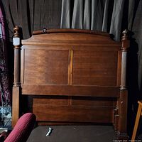 Front view of the wooden headboard with carved posts and paneled style.