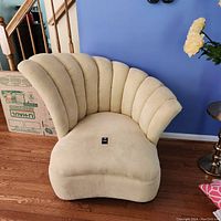 Front view showing scalloped backrest and seat upholstery in beige fabric.