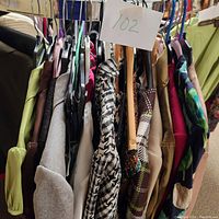 Side view of assorted women's clothing on hangers showing variety of fabrics and colors including animal print and solid colors.