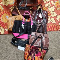 Overview of seven assorted women's handbags and purses arranged on a patterned carpet, showing color, style, and condition.