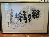 Full front view of the framed Chinese calligraphy print leaning on hardwood floor