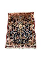 Front view of aged Hamadan backrest rug showing overall floral pattern and color, with visible signs of staining and low pile wool construction.