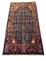 Full view of the Persian Hamadan rug laid flat showing the overall geometric diamond central field with floral accents and pink border with floral abstract motifs.