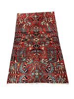 Full view of rectangular Persian Lili rug with red floral pattern, showing design and size.