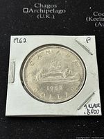The obverse side of the 1962 Canadian silver dollar coin showing the date, condition letter 'F', and silver content label on the holder.