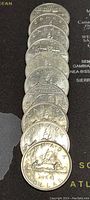 Top view of 10 stacked Canadian silver dollar coins, front side showing the sailing ship design, dated 1968.