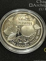 Obverse side of the coin showing the apple design with leaves and inscription.