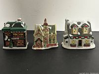 Front view of three ceramic Christmas village buildings: a restaurant, church, and house