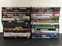 Stack of 30 DVD movies showing colorful titles and cases, mostly in good shape.