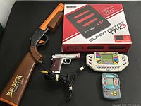 All five video game related items displayed together showing variety of accessories and handheld games included in the lot.