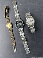 Three wristwatches laid flat showing full bracelets and watch faces: gold-tone Birks with round dial, silver Casio digital watch, and Seiko silver-tone quartz watch missing back cover.