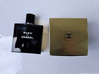 Photo of the 100ml Chanel Bleu de Chanel men's cologne bottle and closed gold boxed soap with Chanel logo.