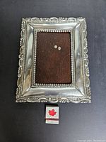Front view of the vintage sterling silver 950 photo frame with detailed design and a matchbox for scale.