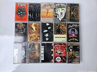 Overview photo showing front covers of 16 different vintage thrash metal cassette tapes including Testament, Sepultura, Megadeth and others