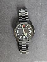 Photo showing front of vintage Swiss Army watch with black dial, white numerals, luminous hands, date window, and metal bracelet.