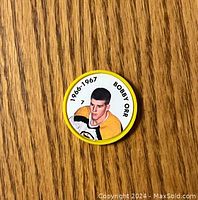 Front view of yellow hockey coin with color image of Bobby Orr and date 1966-1967
