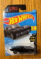 Front view of unopened Hot Wheels Batmobile package showing the black Batmobile toy car, Hot Wheels logo, Batman logo, and series information.