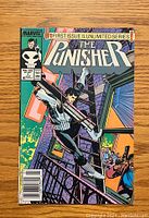 Front cover of The Punisher #1 comic book showing character with guns on a rooftop, Marvel logo and issue information visible.