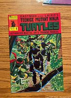 Front cover of Teenage Mutant Ninja Turtles #1 comic book showing the four ninja turtles in a forest wallpaper with martial arts equipment and colorful title text.