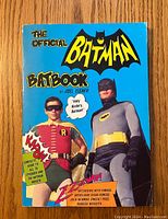 Front cover of 'The Official Batman Batbook' showing Batman and Robin in full costume with colorful comic-style text.