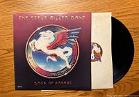 Vinyl record partially pulled out of its sleeve showing label with colored winged horse emblem