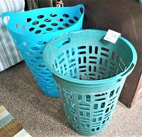 Side view of two plastic laundry baskets showing ventilation designs and handles.