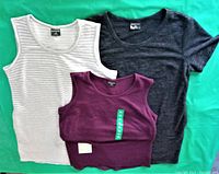 Group photo of three ladies dresses laid flat: white/grey striped sleeveless, black short sleeve, and burgundy sleeveless.