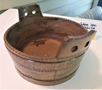 Top angled view showing round shape, two handles with holes, and interior wear