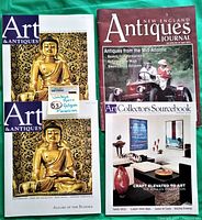 Four vintage art and antiques magazines laid out on green fabric as lot contents.