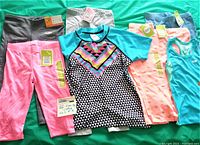 Full overview of lot showing multiple clothing items including a patterned top and leggings
