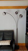 Full view of floor lamp showing three adjustable heads with tinted glass shades and curved metal arms.