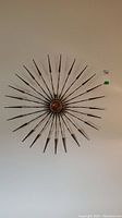 Front view of the starburst wall art showing full radial design with tapering rods and copper center.