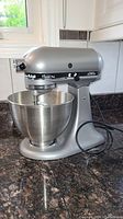 Side view of silver mixer with bowl attached on countertop