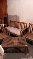Full set with bench, two chairs and coffee table arranged in basement.