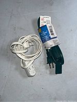 Photo of two 6-foot extension cords, one white used extension cord and one green extension cord in original packaging.