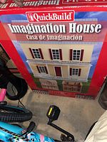 Front of unopened QuickBuild Imagination House dollhouse kit box, showing product name and promotional text.