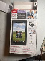 Box of RCA Pro10 Edition tablet showing tablet image and features, including 10.1'' display, 16GB storage, USB keyboard folio case, HDMI port, quad core processor, and Wi-Fi.