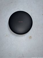 Top view of black Samsung wireless charger showing 'FAST CHARGE' text on leather-textured surface.