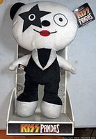 Front view of KISS Panda plush doll in black vest and pants with star eye patch, original tag attached, sitting on a box.