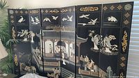 Full view of the 6 panel folding screen showing detailed colored carvings of geishas, architecture, birds, and decorative motifs on one side.