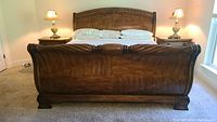 Front view of the king size AICO brand sleigh bed showing headboard, footboard, and supporting posts.