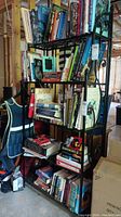 Full view of the black metal shelf filled with books and other basement items