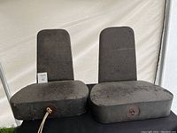 Front view of two black foam chair forms with valves on base