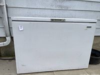 Front view of white chest freezer with minor scuff marks.
